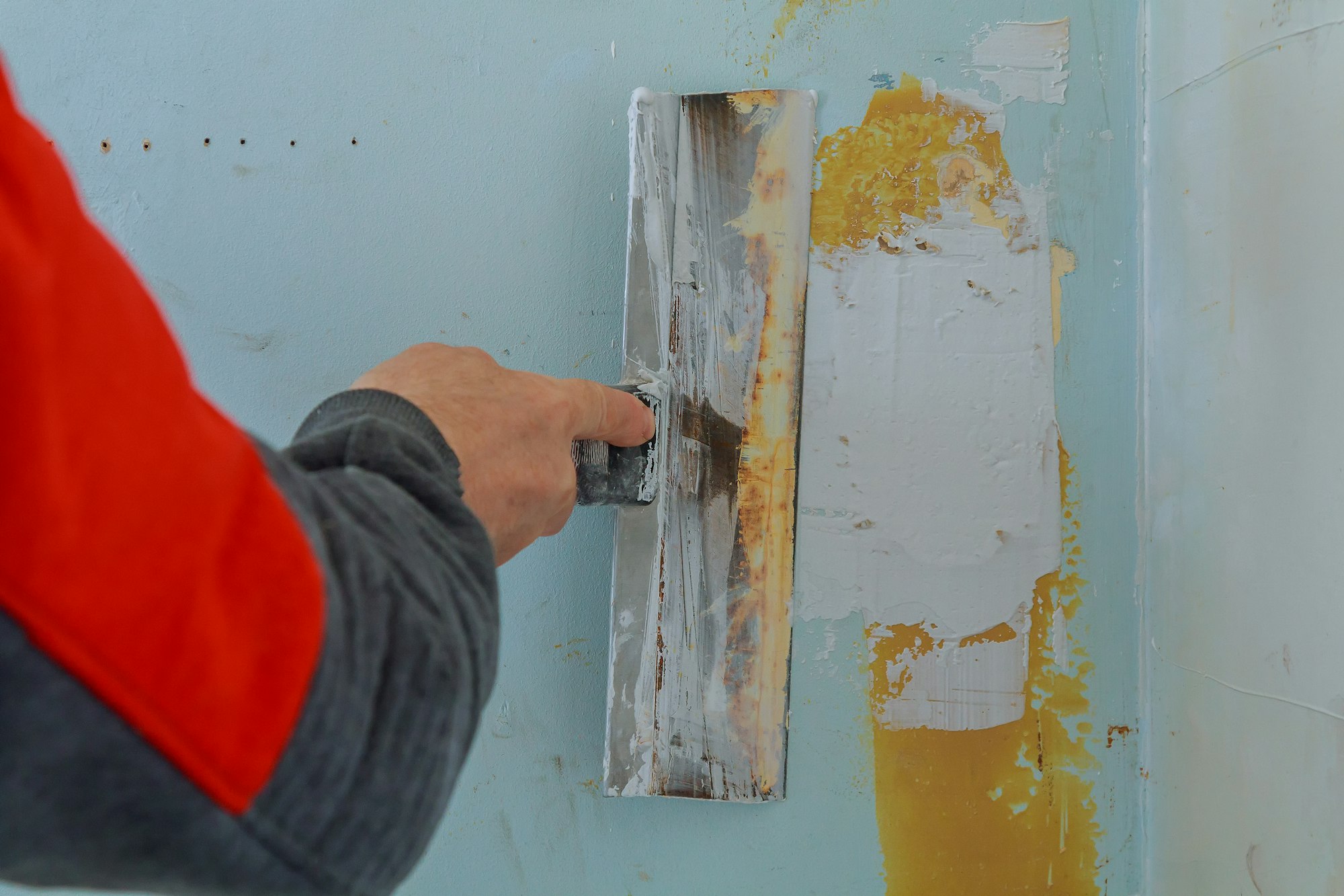 Male builder makes repairs in the apartment