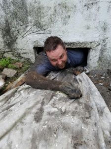 Handyman climbing out a basement window